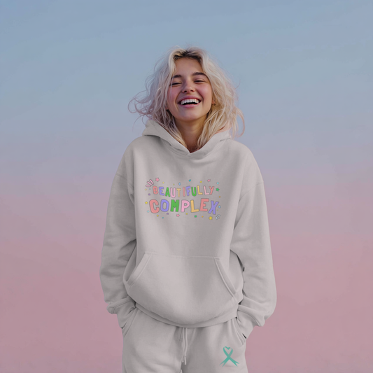 Person wearing a light gray hoodie with colorful text on a gradient background