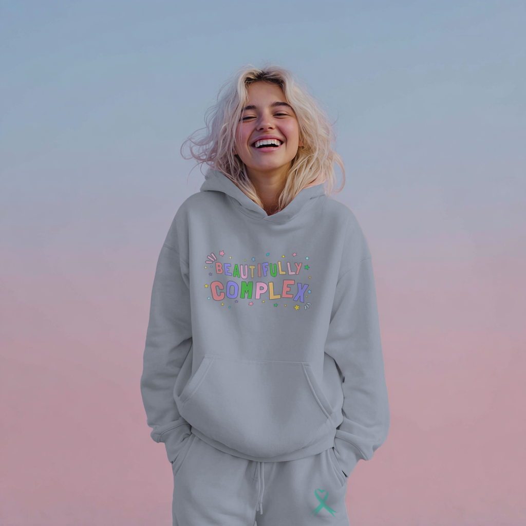 Person wearing a gray hoodie with colorful text on a gradient background